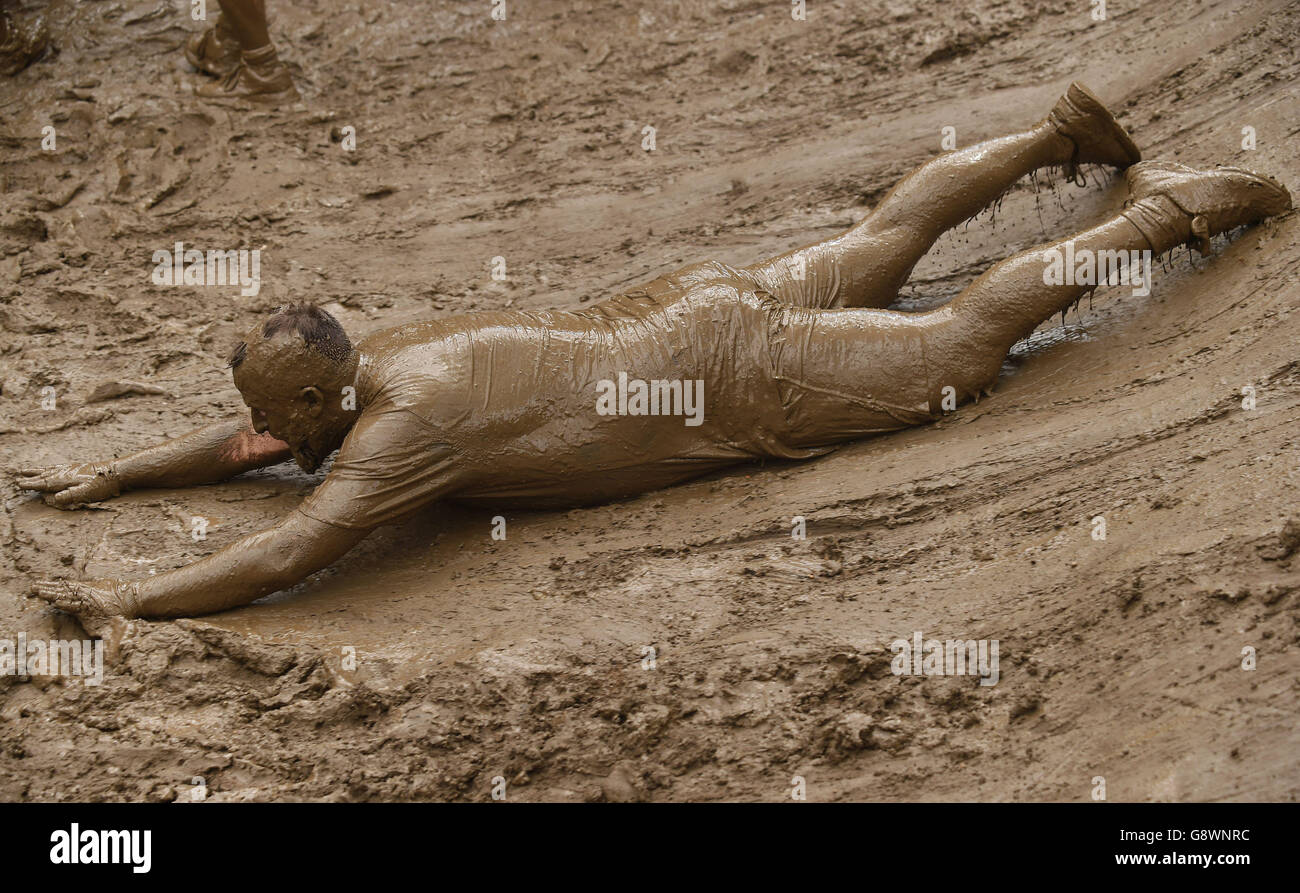 Un participant glisse sur la boue lors de l'événement « King of the Konims » Tough Mudder London West au Culden Faw Estate près de Henley-on-Thames. Banque D'Images