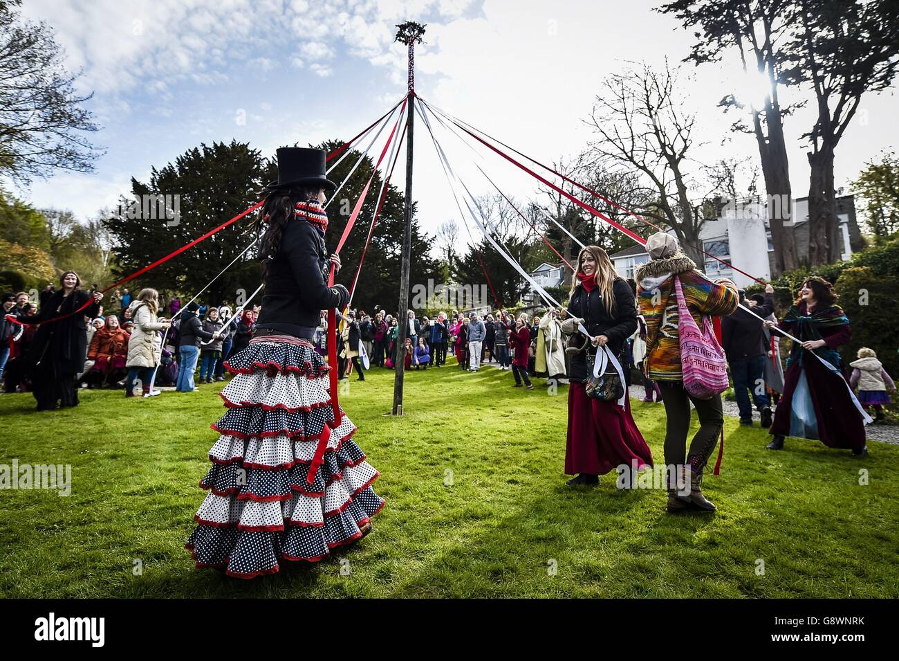 Les gens prennent part à la danse traditionnelle de la maypole dans le puits de Chalice, Glastonbury, où les festivités de Beltane ont lieu le jour de mai. Banque D'Images
