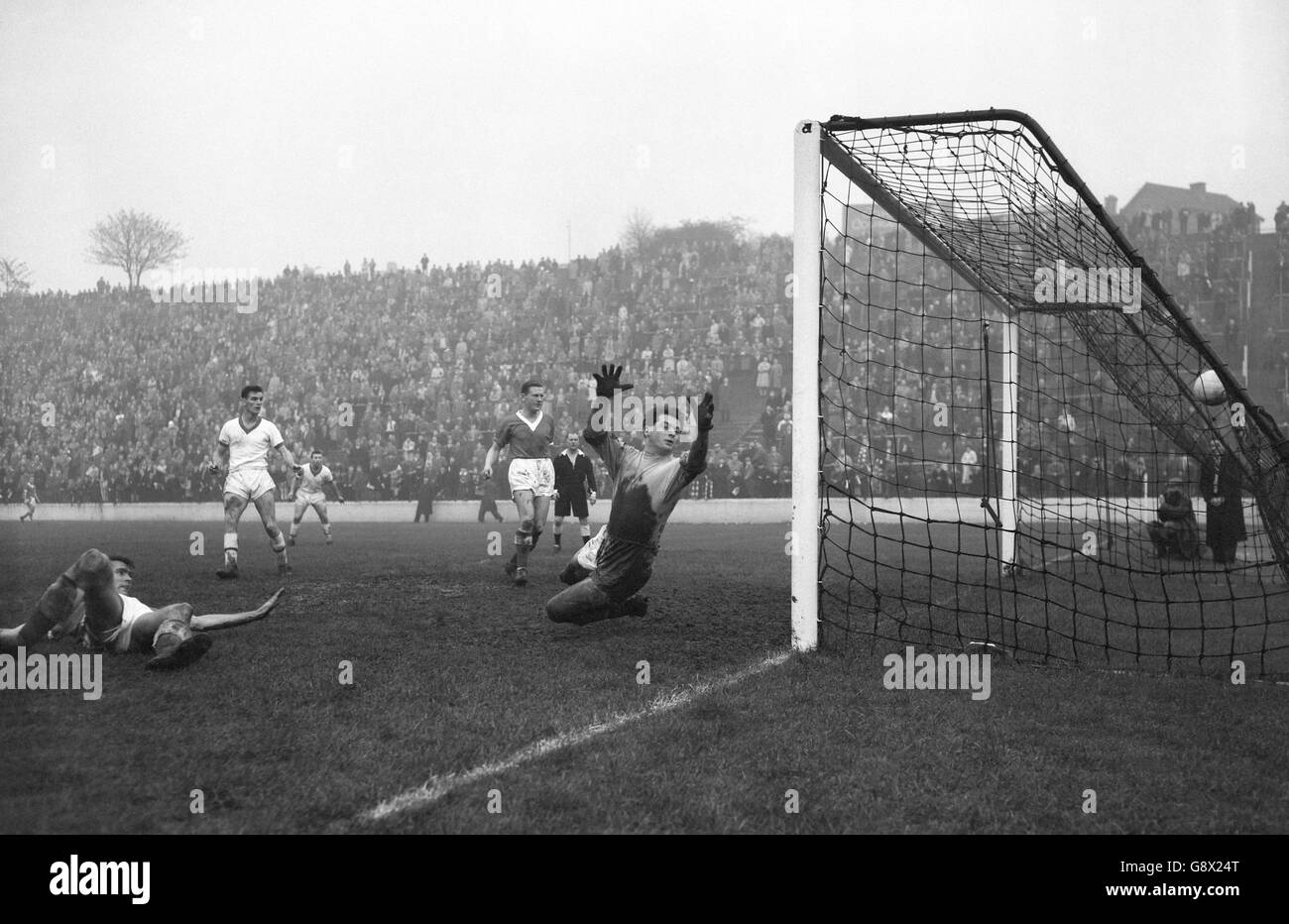 Le gardien de but de Charlton Athletic Willie Duff lance ses mains dans une vaine tentative de sauver, mais le ballon vole à l'arrière du filet pour le cinquième but de Middlesbrough - marqué par Burbeck à l'extérieur-gauche - dans le deuxième match de division à la Vallée.Le match a terminé un tirage de 6-6. Banque D'Images