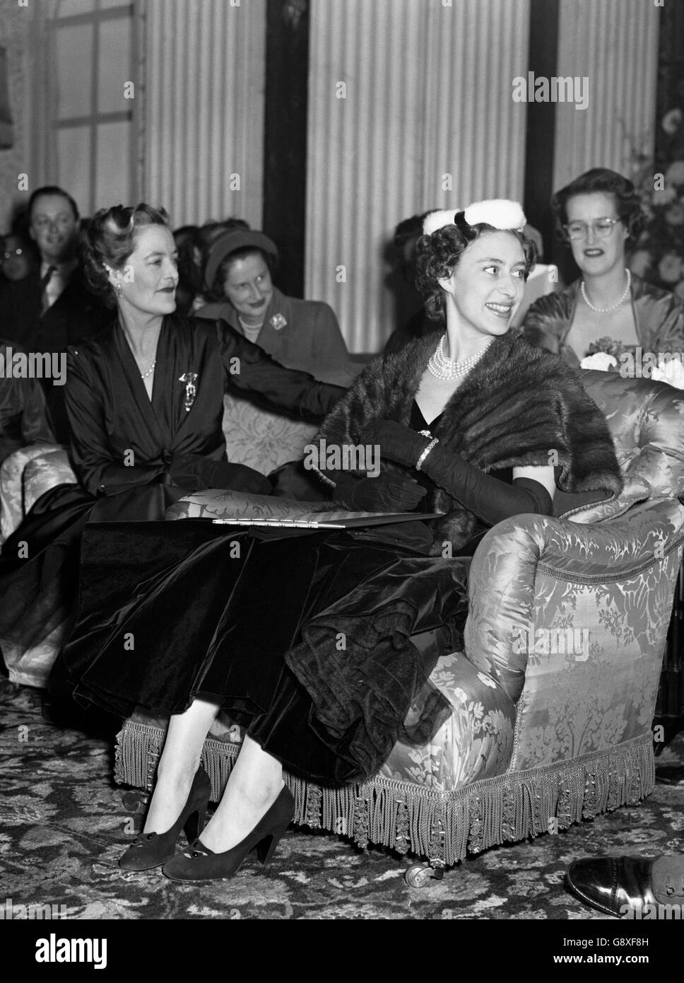 Une princesse souriante Margaret, assise à côté de la duchesse de Marlborough, regarde une présentation de la collection d'hiver de Christian Dior qui s'est tenue au Palais de Blenheim en aide à la Société britannique de la Croix-Rouge. Banque D'Images