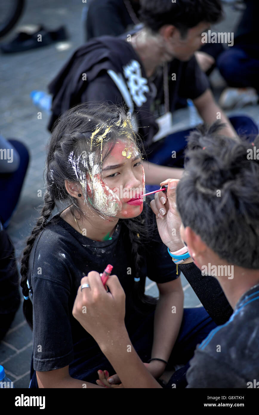 Peinture faciale.les adolescents thaïlandais organisent une manifestation de moquerie de rue contre la vanité excessive en appliquant le maquillage farcical de visage. Thaïlande S. E. Asie Banque D'Images