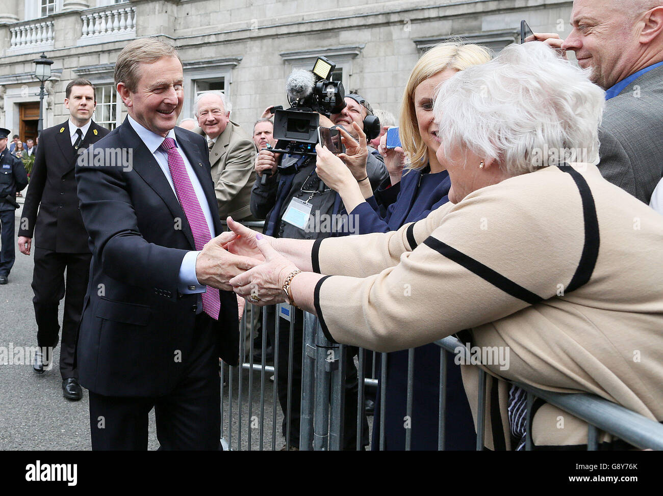 Taoiseach, nouvellement élu, Enda Kenny accueille les partisans alors qu'il quitte Leinster House, Dublin, pour aller à Aras an Uachtarain pour recevoir le sceau de la Taoiseach et le sceau du gouvernement. Banque D'Images