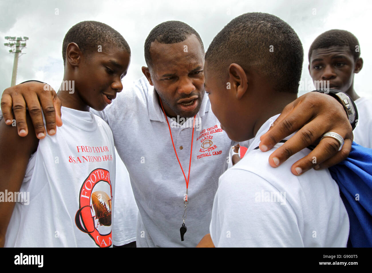 En Floride, aux États-Unis. 1er juillet 2016. 070310 (Allen Eyestone/Le Palm Beach Post) Belle Glade, FL New England Patriots running back Fred Taylor parle avec Charles Daniels (à gauche), 13 ans, de South Bay et Anthony Bowie, 9, de Pahokee au Fred Taylor et Santonio Holmes sous-Bois All-Star Football à Pioneer Park à Belle Glade. Taylor était meilleurs amis avec les pères des garçons à l'école secondaire. Taylor leur a dit de suivre leurs rêves, ne jamais renoncer et à rester hors de l'ennui. Plus de 150 enfants ont participé au camp gratuitement. Ancien sous-Bois salon joueurs Ray McDonald, Roosevelt Blackmon, Deonte Thompson, Reide Banque D'Images