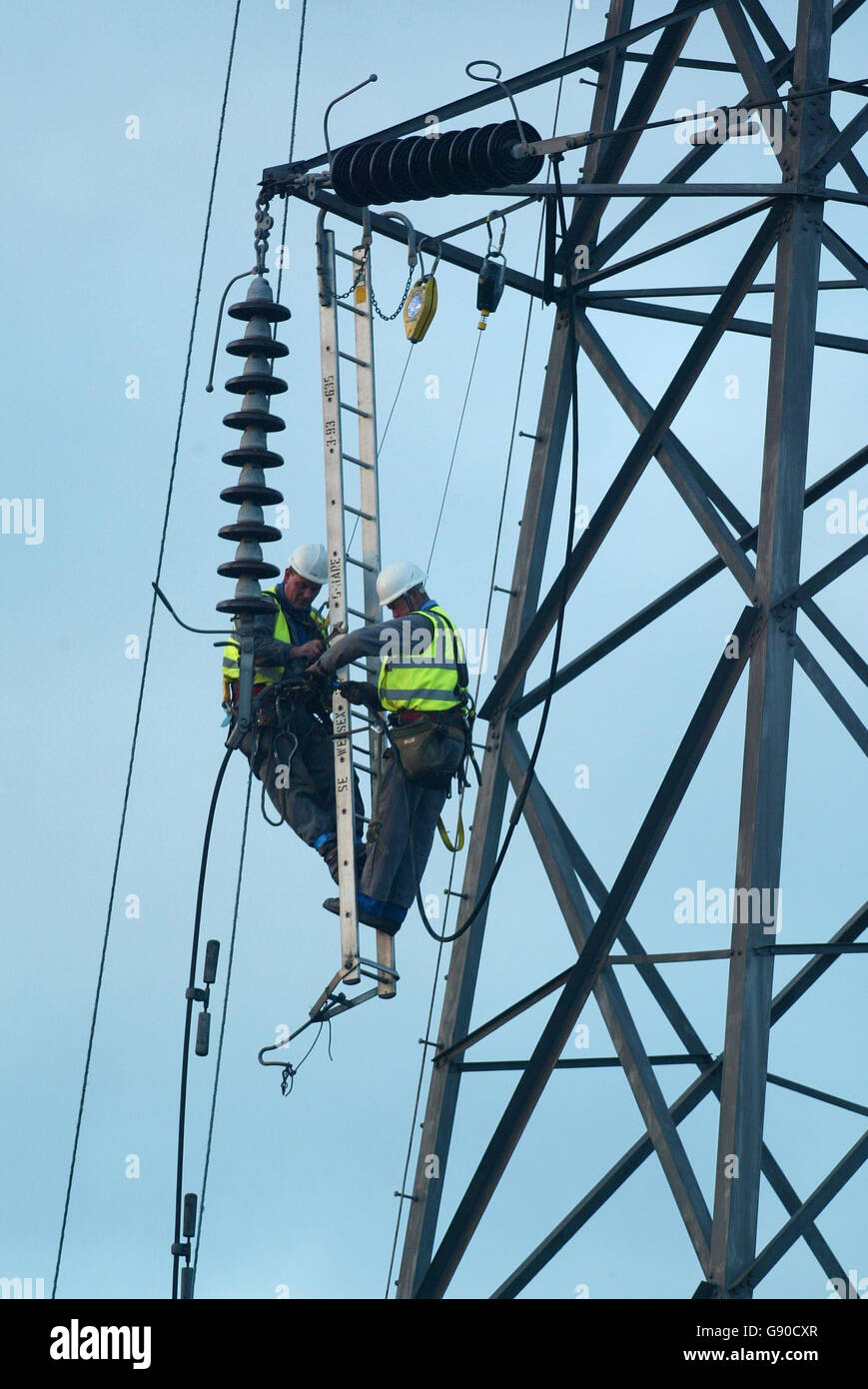 Les travailleurs de l'électricité réparent les lignes électriques qui ont été mises à l'arrêt par un énorme incendie à Nelson Stanley Scrap Merchants à Bournemouth, le mardi 15 2005 novembre.Un incendie majeur au chantier de raclage a détruit une ligne de réseau haute tension aujourd'hui qui a fait tomber des câbles d'électricité sur les jardins et les routes.Des voitures ont explosé dans les marchands de ferraille de Nelson Stanley Ltd, sur le chemin Alder, à Poole, Dorset, et un grand panache de fumée a été émis par le feu qui a commencé vers 8 heures aujourd'hui.Voir l'article sur les câbles D'INCENDIE.APPUYEZ SUR ASSOCIATION photo.Photo Credit devrait se lire: Chris Ison/PA Banque D'Images