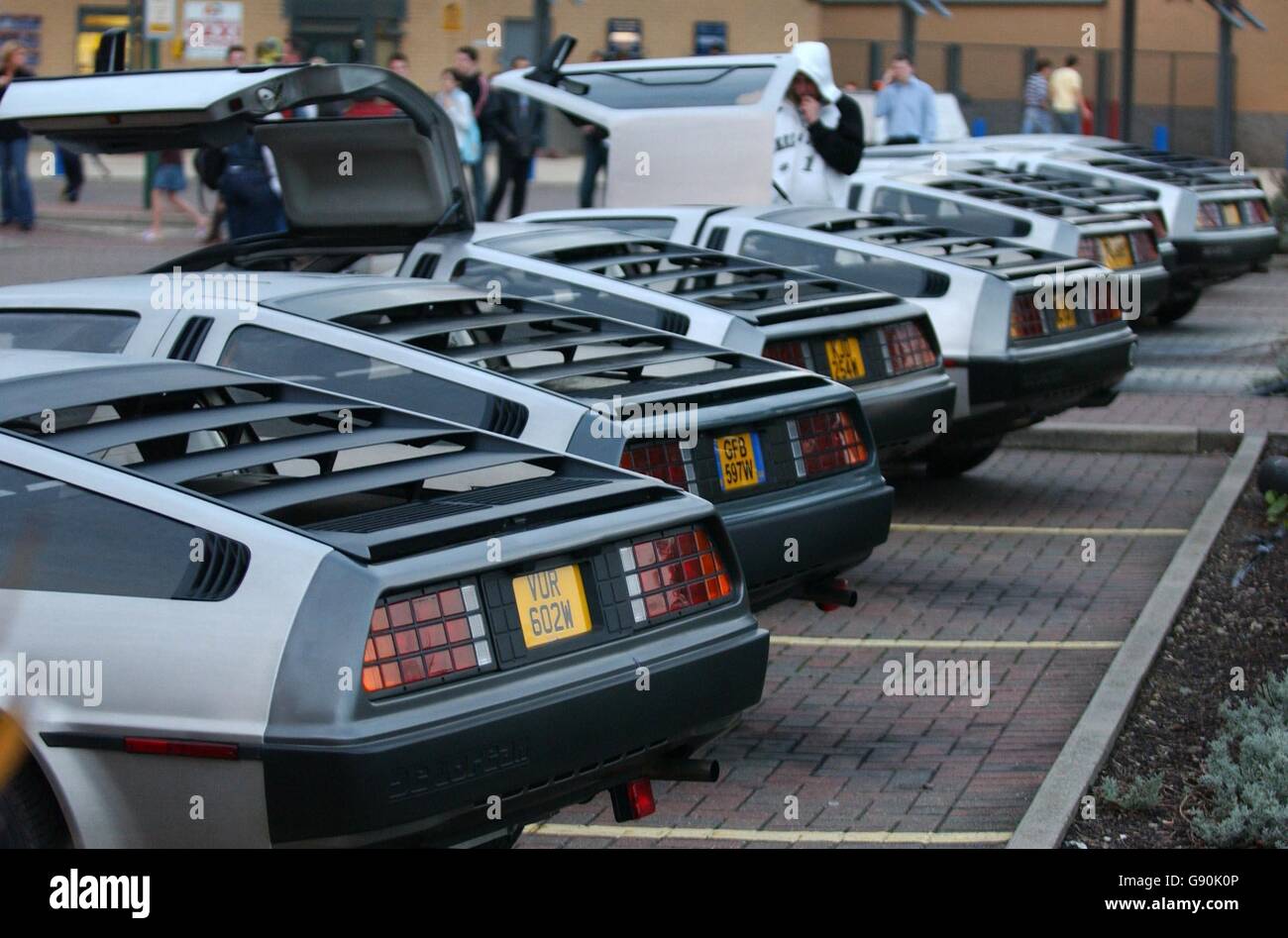 Les visiteurs regardent les voitures Delorean exposées au cinéma UCI de Basildon, pour marquer une exposition spéciale de la trilogie Back to the future films. Dans un rare cas, plus de 20 voitures célèbres ont été achetées ensemble par le Delorean Owners Club. Banque D'Images