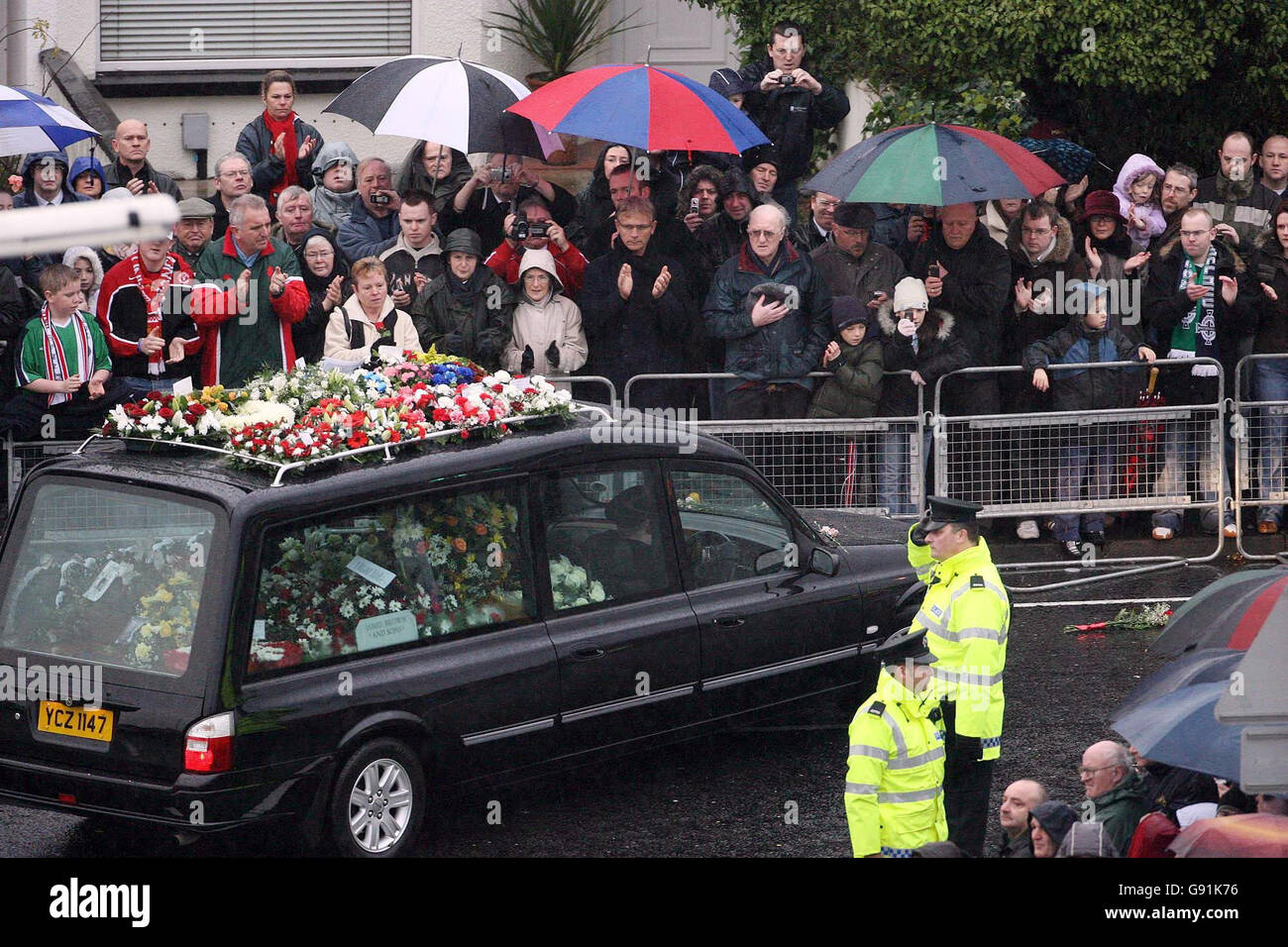 Les adeptes de la mode applaudissent tandis que le cortège funéraire de George Best traverse le domaine de Cregagh à Belfast est, le samedi 3 décembre 2005. Le monde du football payait aujourd'hui ses derniers égards, car Best, l'un des plus grands joueurs de l'histoire, a été mis au repos. BEST, 59 ans, est décédé vendredi dernier à l'hôpital Cromwell de Londres. Voir PA Story FUNÉRAILLES Best. APPUYEZ SUR ASSOCIATION photo. Le crédit photo devrait se lire comme suit : Niall Carson/PA. Banque D'Images