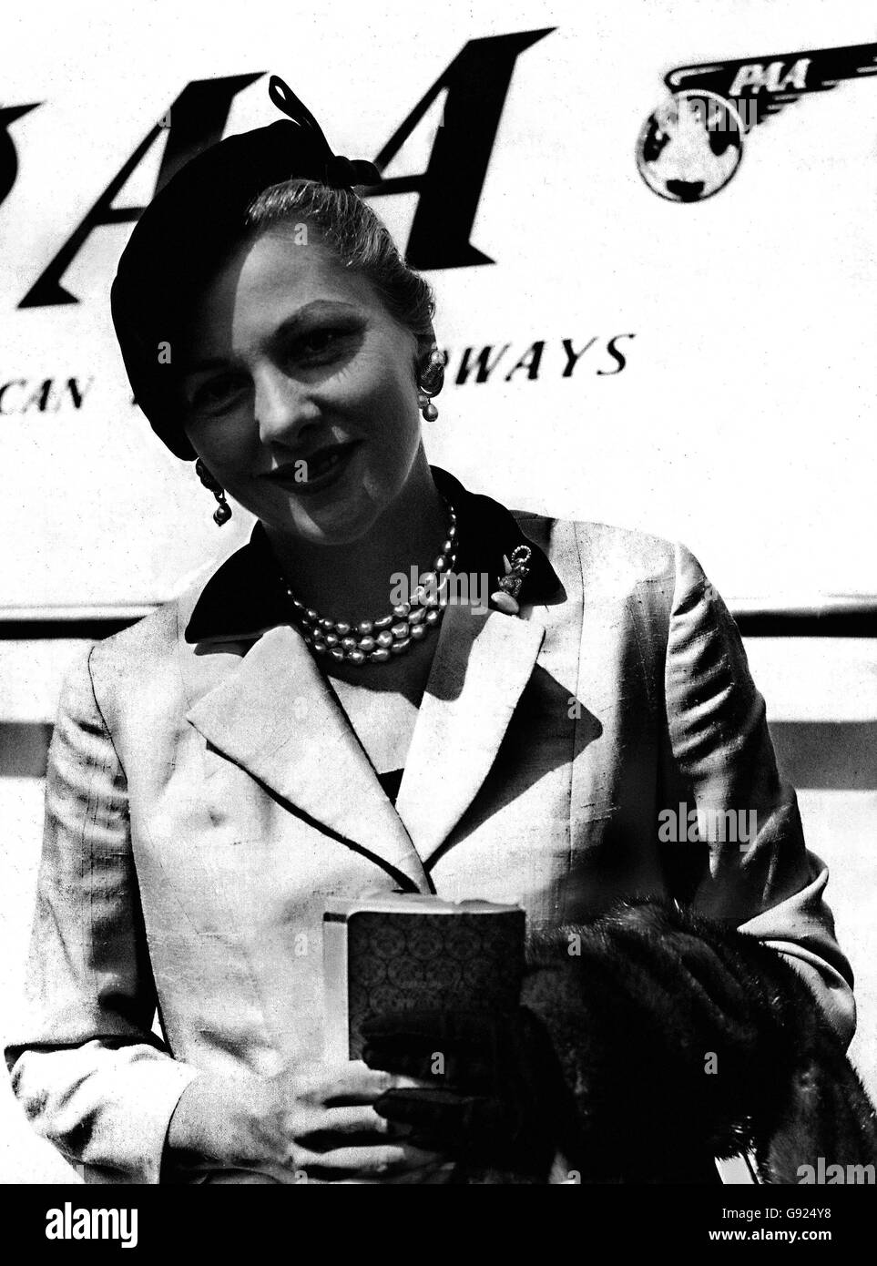 La star de cinéma Joan Fontaine, recouverte d'une gaine froide pour la canicule britannique, arrive à l'aéroport de Londres en avion panaméricain de New York pour des discussions sur un nouveau film. Banque D'Images