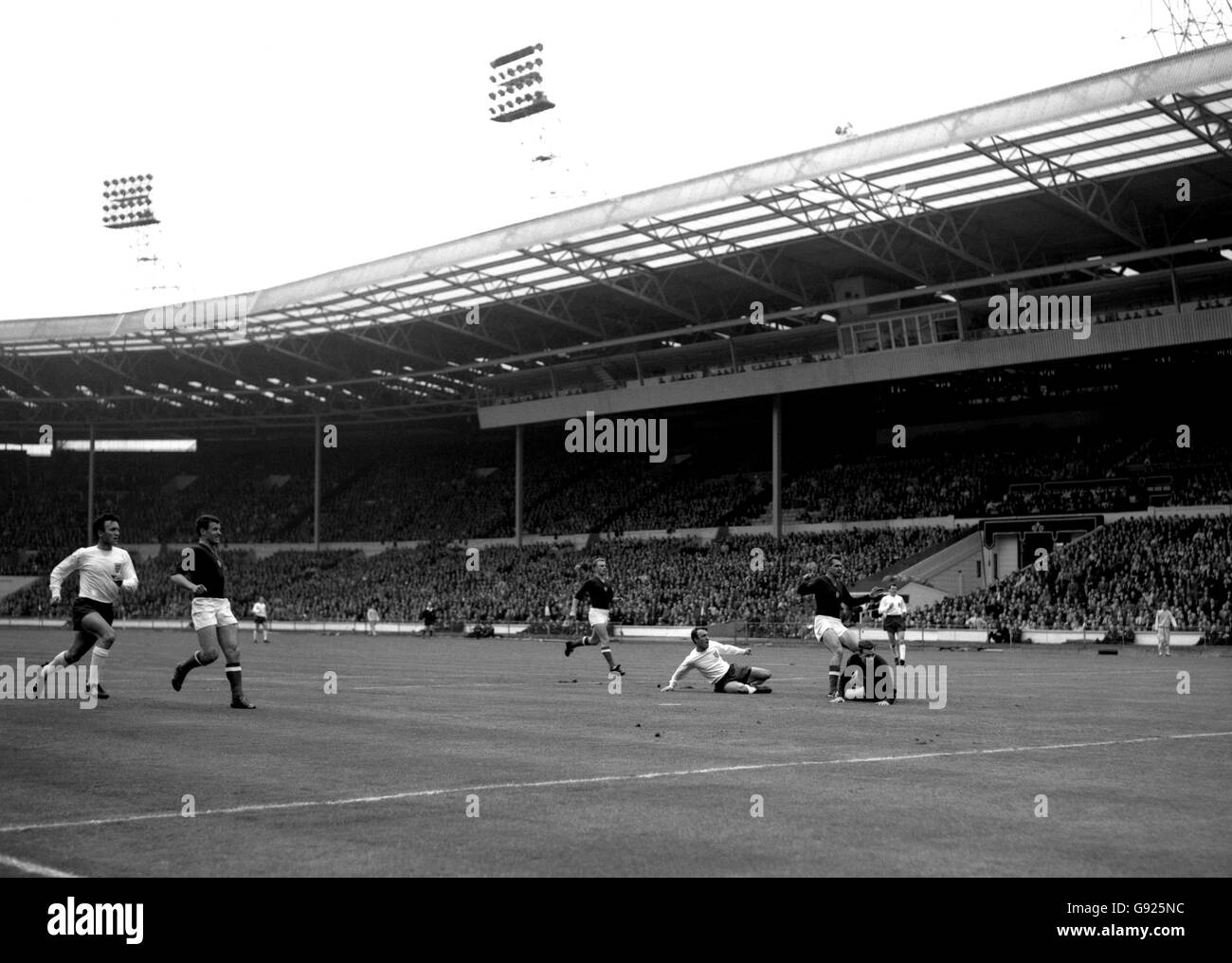 Angleterre à l'intérieur-droit Jimmy Greaves (au sol à gauche) marque le premier but de l'Angleterre après avoir battu le centre arrière de la Hongrie Kalman Meszoly. Sur le terrain se trouve le gardien de but hongrois Jozsef Gelei, et en arrière-plan à droite se trouve John Connelly, l'Angleterre à l'extérieur à gauche. Banque D'Images