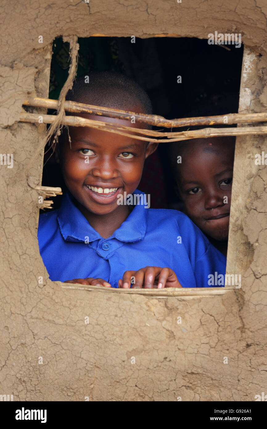 Les filles à la recherche par la fenêtre d'une hutte de boue, le Rwanda, l'Afrique Banque D'Images