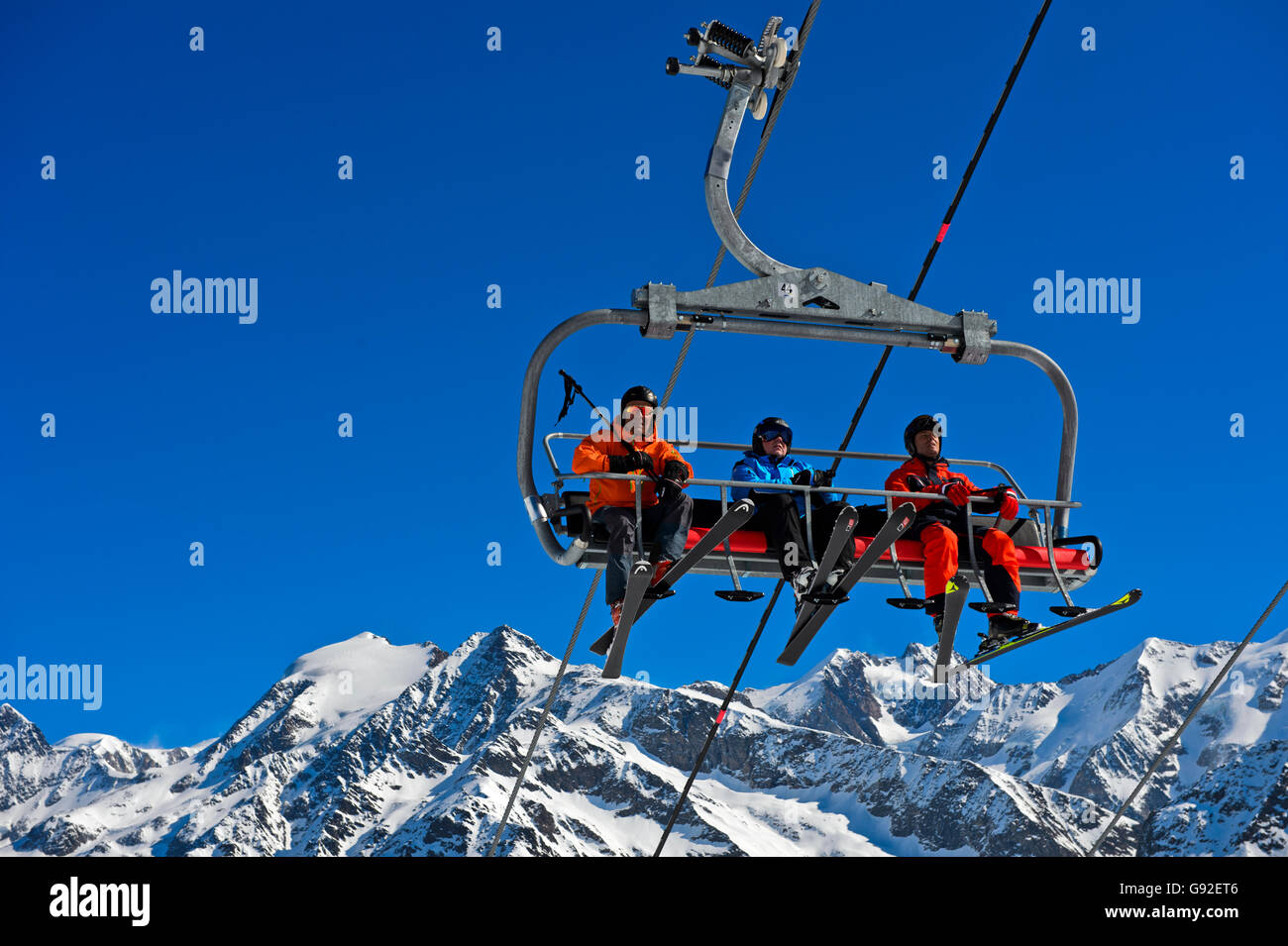 Skieurs sur un télésiège dans la station de ski Les Contamines-Montjoie, derrière le massif du Mont Blanc, Haute-Savoie, France Banque D'Images