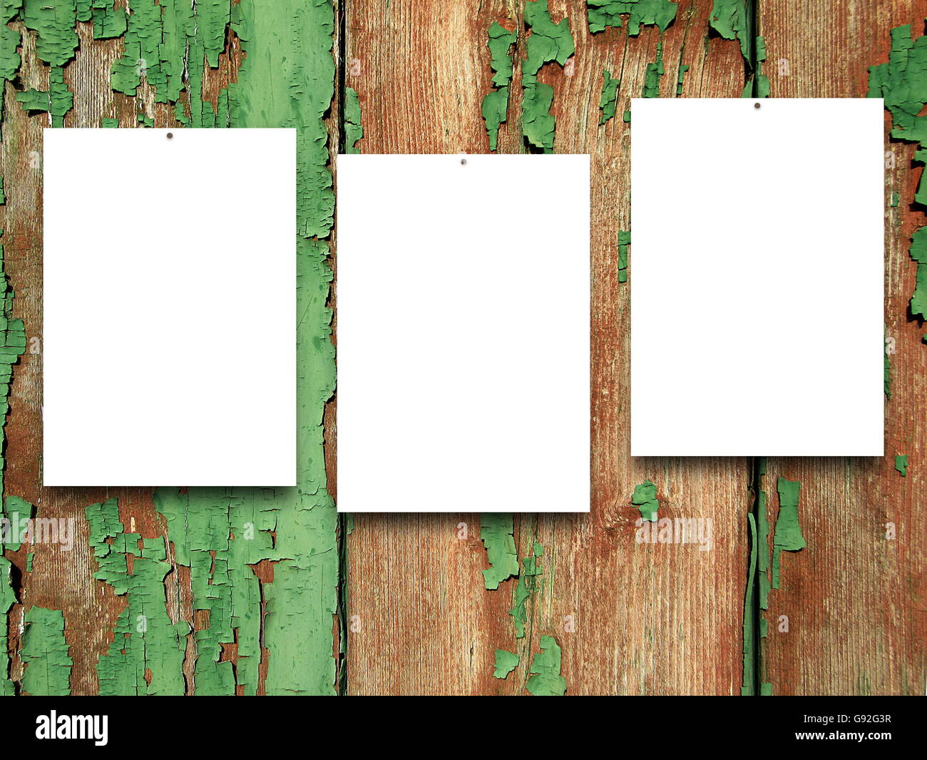 Close-up de trois images vierges cloué sur vert et marron rayé des planches en arrière-plan Banque D'Images