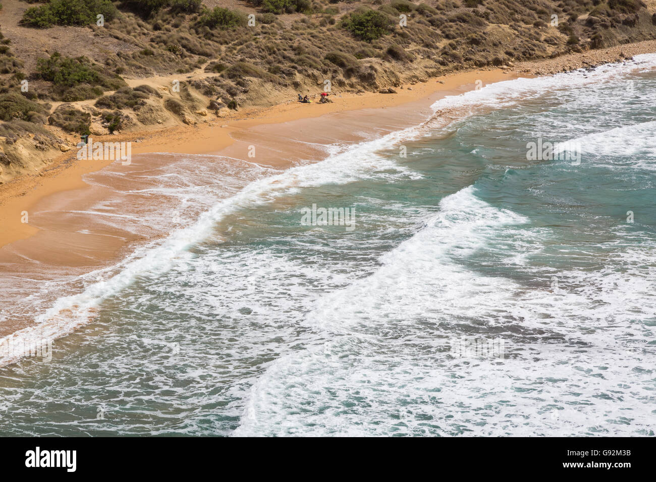 La plage de sable au-dessous les falaises rocheuses de l'île de Malte Banque D'Images