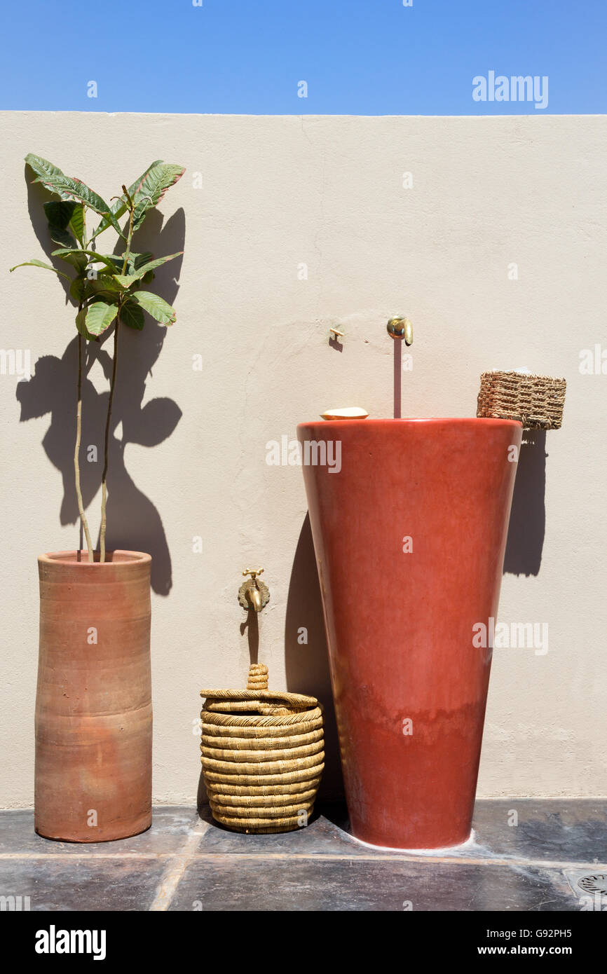 Évier et plante contre un mur dans un pays chaud. Banque D'Images