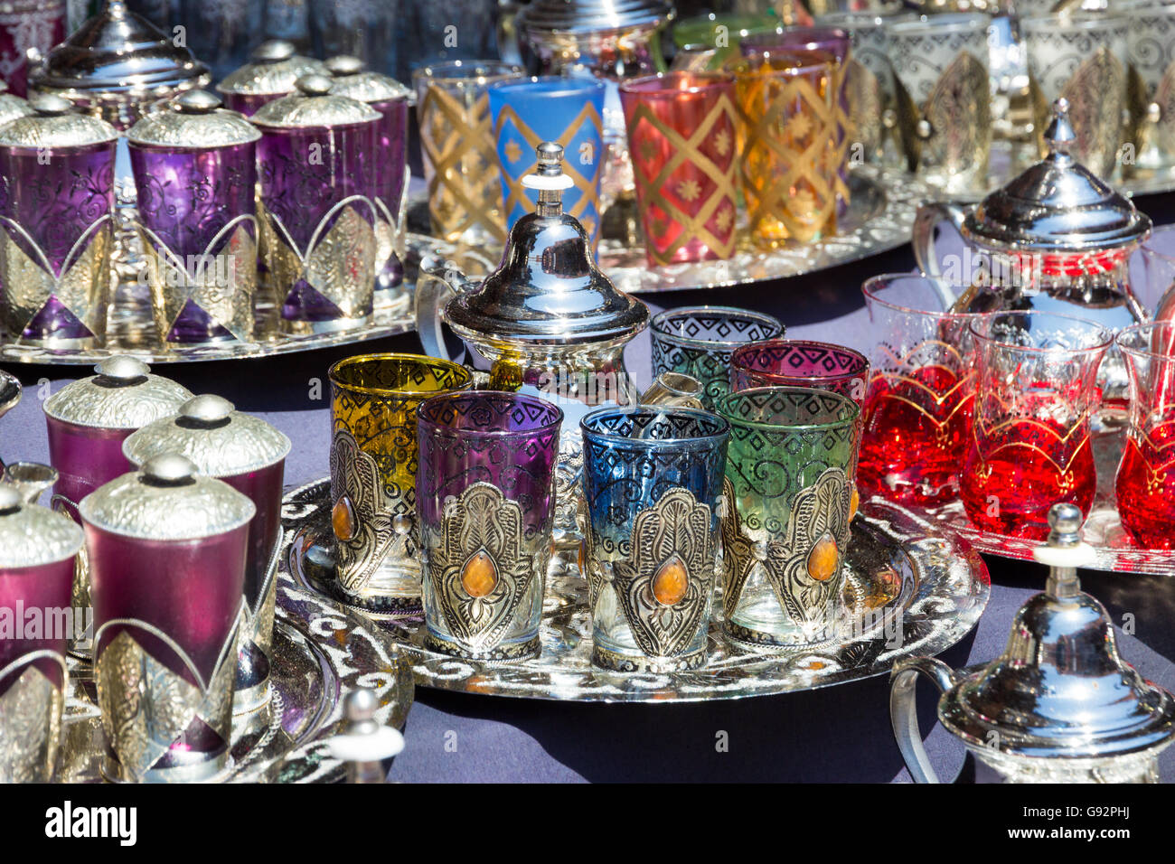 Théières traditionnelles avec des verres à thé sur un plateau vendus dans les souks de Marrakech, Maroc Banque D'Images