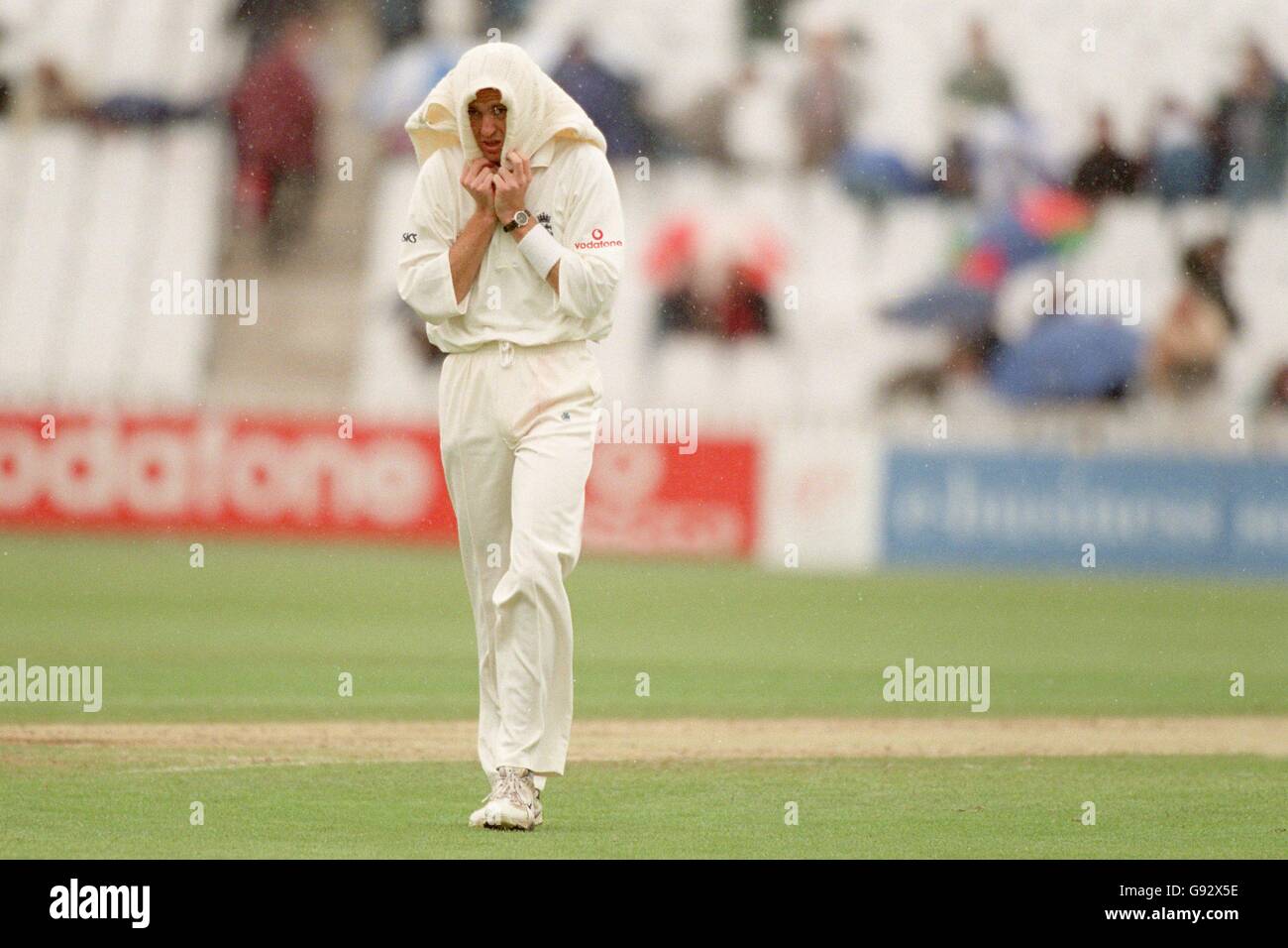 Dominic Cork, en Angleterre, se protège de la pluie de Birmingham Le jeu est suspendu pendant la quatrième journée à Edgbaston Banque D'Images