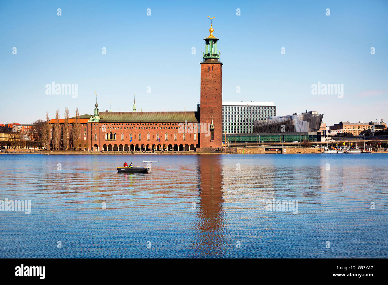 Personnes dans un bateau en face de l'Hôtel de Ville de Stockholm. Banque D'Images