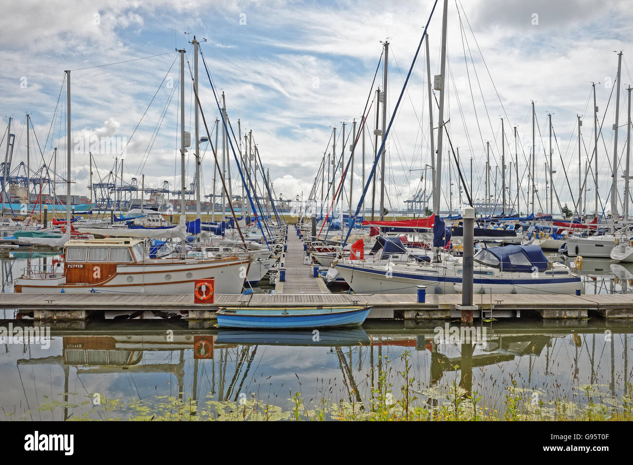 Yachts amarrés dans Shotley Marina, Suffolk, UK avec Felixstowe port à conteneurs à l'arrière-plan Banque D'Images