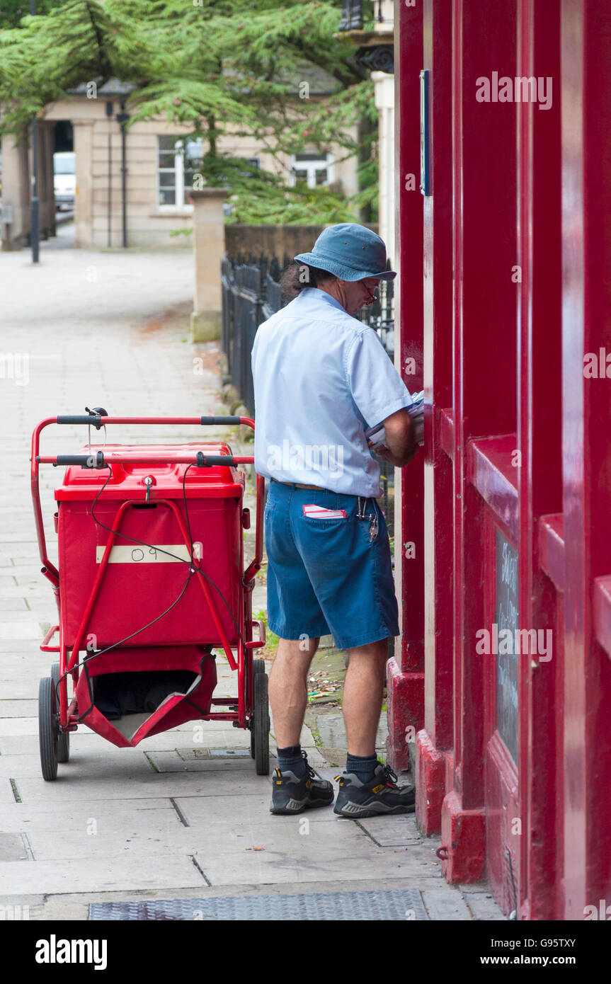Postman fait une livraison à Bath, Somerset, England, UK Banque D'Images