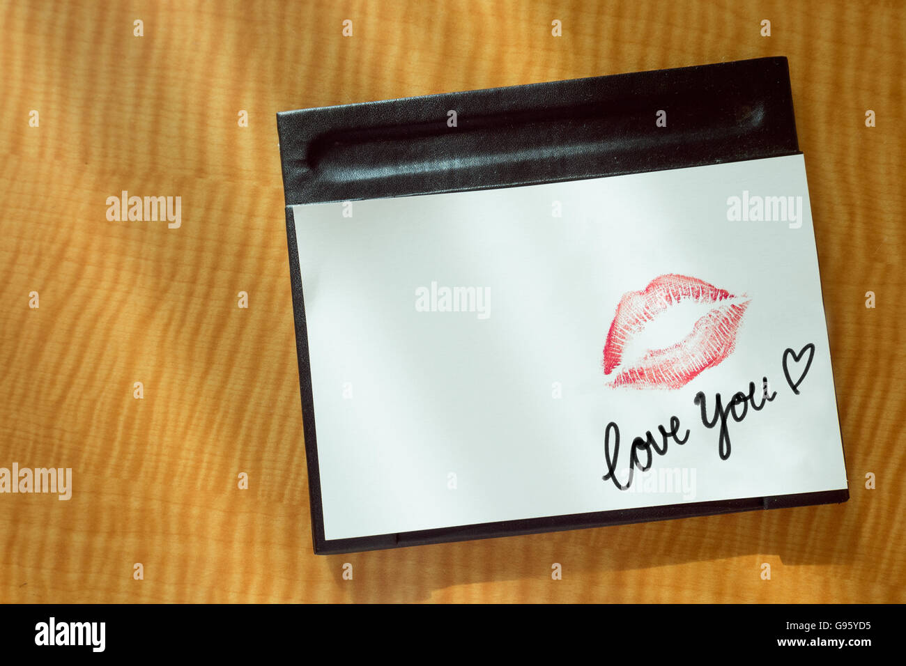 Sexy Girl Red Lips kiss et 'aime' mot écrire sur papier blanc sur lit table de peuplement dans la lumière du matin message romantique. Banque D'Images