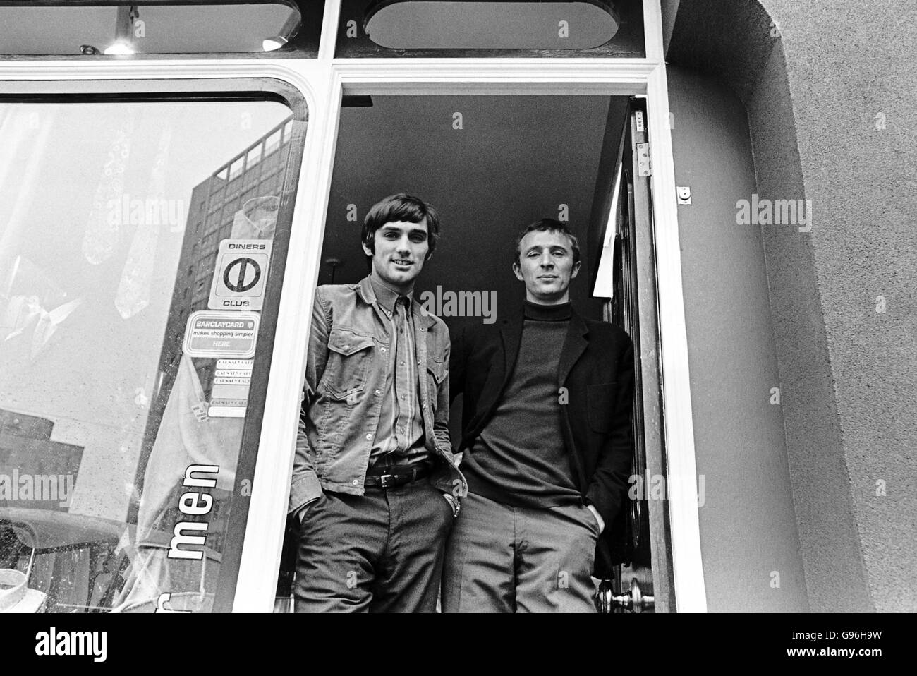 George Best (à gauche) et Mike Summerbee (à droite) debout à l'intérieur de leur boutique de vêtements pour hommes Banque D'Images