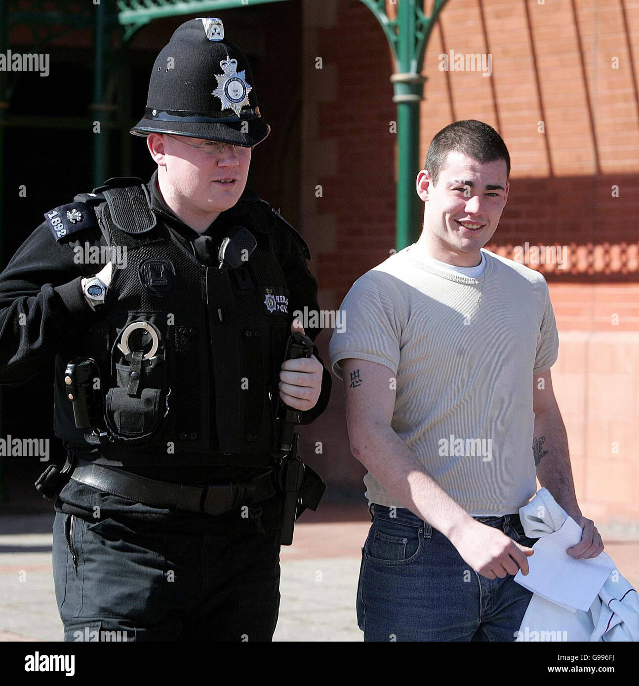 Damien Français quitte le tribunal de Llandudno, flanqué d'un policier, après avoir été condamné à six mois de prison avec sursis, le mercredi 5 avril 2006.Français, 20 ans, qui a lancé le lapin d'un zoo aux alligators, a été épargné un sort derrière les bars aujourd'hui.Il a arraché un lapin sans défense dans une section de pétulage du zoo de Welsh Mountain à Colwyn Bay, dans le nord du pays de Galles, puis l'a déposé dans la piscine d'alligators voisine où il a été immédiatement sauvé par Albert, un gros alligator mâle, qui a maintenu son corps entre ses mâchoires.Les Français sans emploi ont été reconnus coupables de cruauté envers les animaux au tribunal de justice de Llandudno Banque D'Images