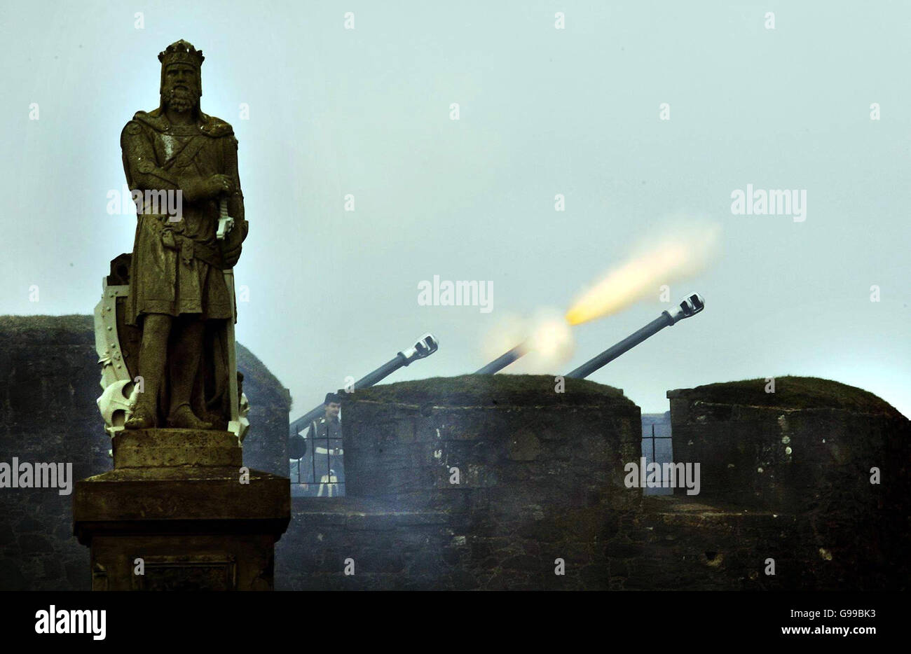Les tireurs du corps de formation des officiers des universités de Glasgow et Strathclyde ont tiré un vingt et un hommage à l'arme à feu au château de Stirling avec une statue de Robert le Bruce en premier plan pour célébrer le 80e anniversaire de la reine Elizabeth II. Banque D'Images