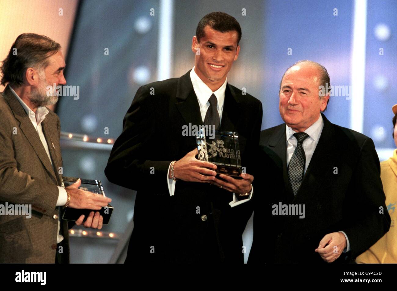 Rivaldo, du Brésil et de Barcelone (c), reçoit à Bruxelles le trophée du joueur mondial de l'année de la FIFA, décerné par le président de la FIFA, Joseph Sepp Blatter (r), sous la direction de George Best (l), qui a reçu le prix des gagnants suivants de David Beckham Banque D'Images