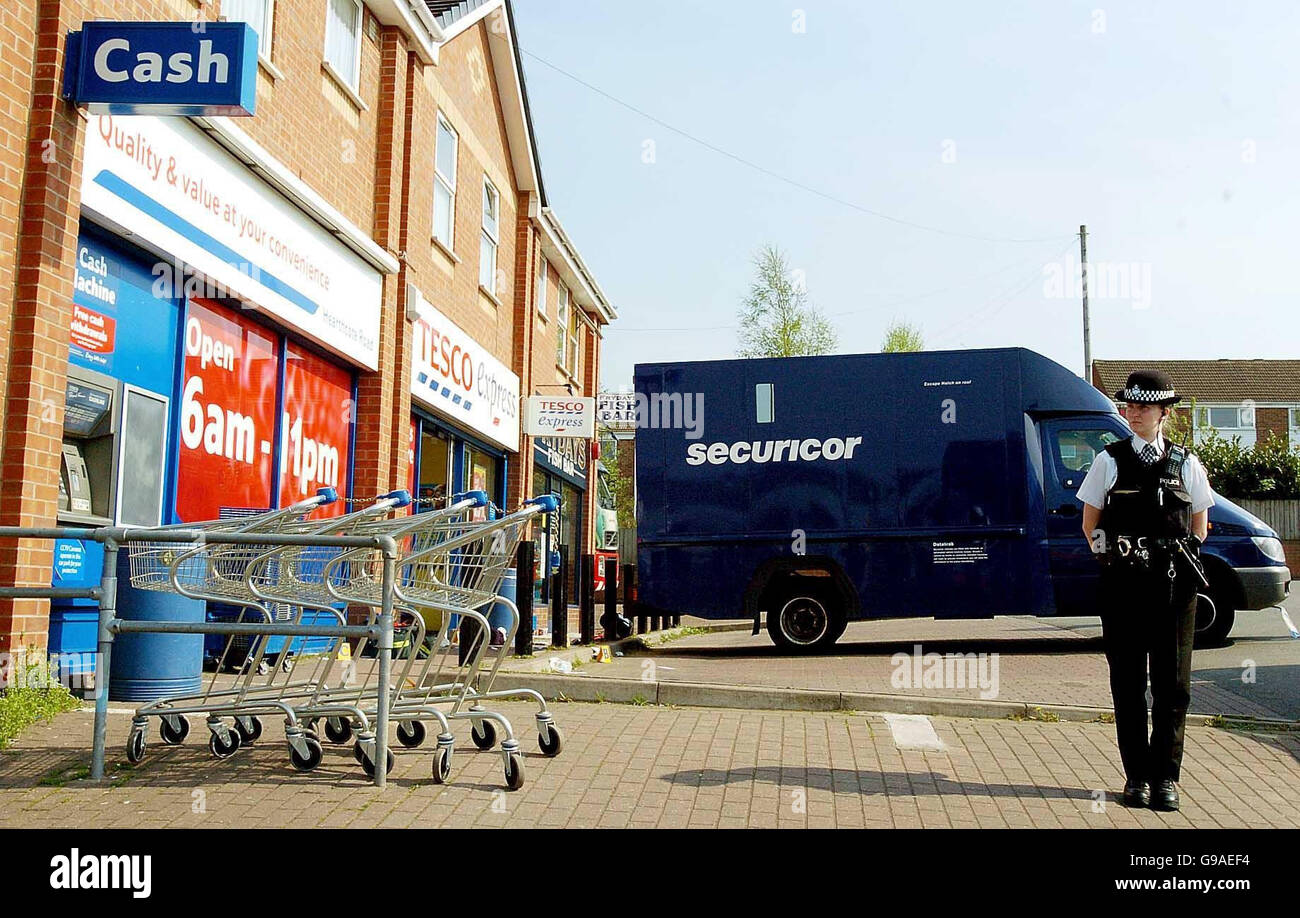 Police à l'extérieur de Tesco Express, Swadlincote où un agent de sécurité de la Securitcor a été abattu dans les jambes lors d'un vol à main armée au supermarché de Derbyshire. Banque D'Images