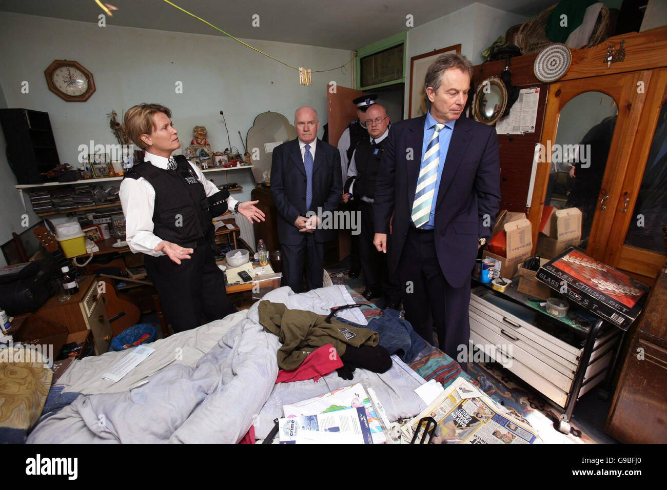 Le sergent de police Sarah Ward (à gauche) et deux policiers communautaires montrent le Premier ministre britannique Tony Blair (à droite) et le secrétaire à l'intérieur John Reid (au centre) l'intérieur d'une ancienne crack House sur le domaine de l'Église Manor, dans le sud de Londres. Banque D'Images