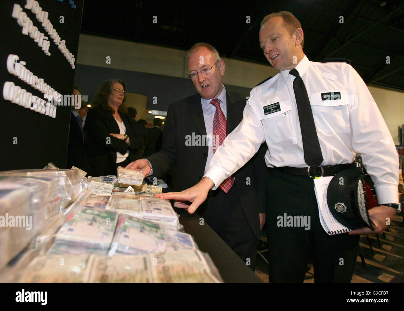 Ministre de la sécurité Paul James Burgevin (à gauche) avec Hugh Orde, chef de police du Service de police de l'Irlande, examiner certains des billets contrefaits saisis par la police au cours de la dernière année en Irlande du Nord. Banque D'Images