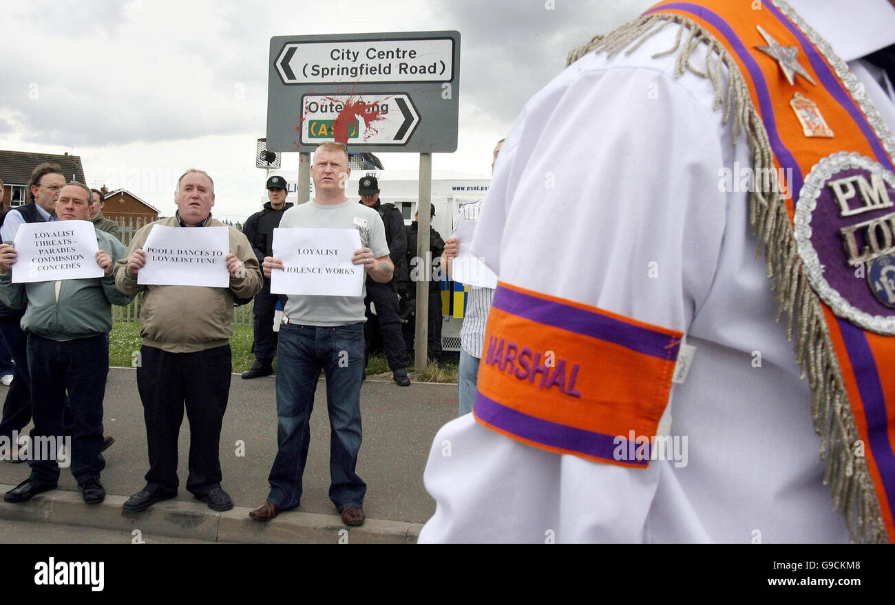 Eddie Copeland (R), un républicain bien connu, et d'autres manifestants nationalistes sur la route de Springfield à Belfast, regardent une parade symbolique d'Orange à travers une zone nationaliste. Banque D'Images