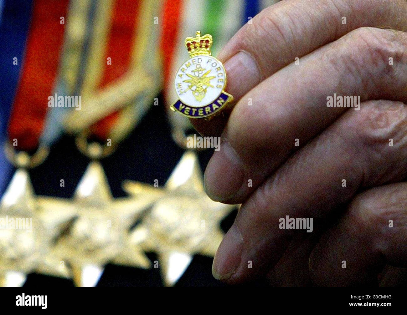 L'ex-militaire Harold Jackson, 87 ans, de Kirkcaldy, détient son insigne lors d'un service de la Journée des anciens combattants et présente des insignes des forces armées au Collège Adam Smith à Kirkcaldy, Fife. Banque D'Images