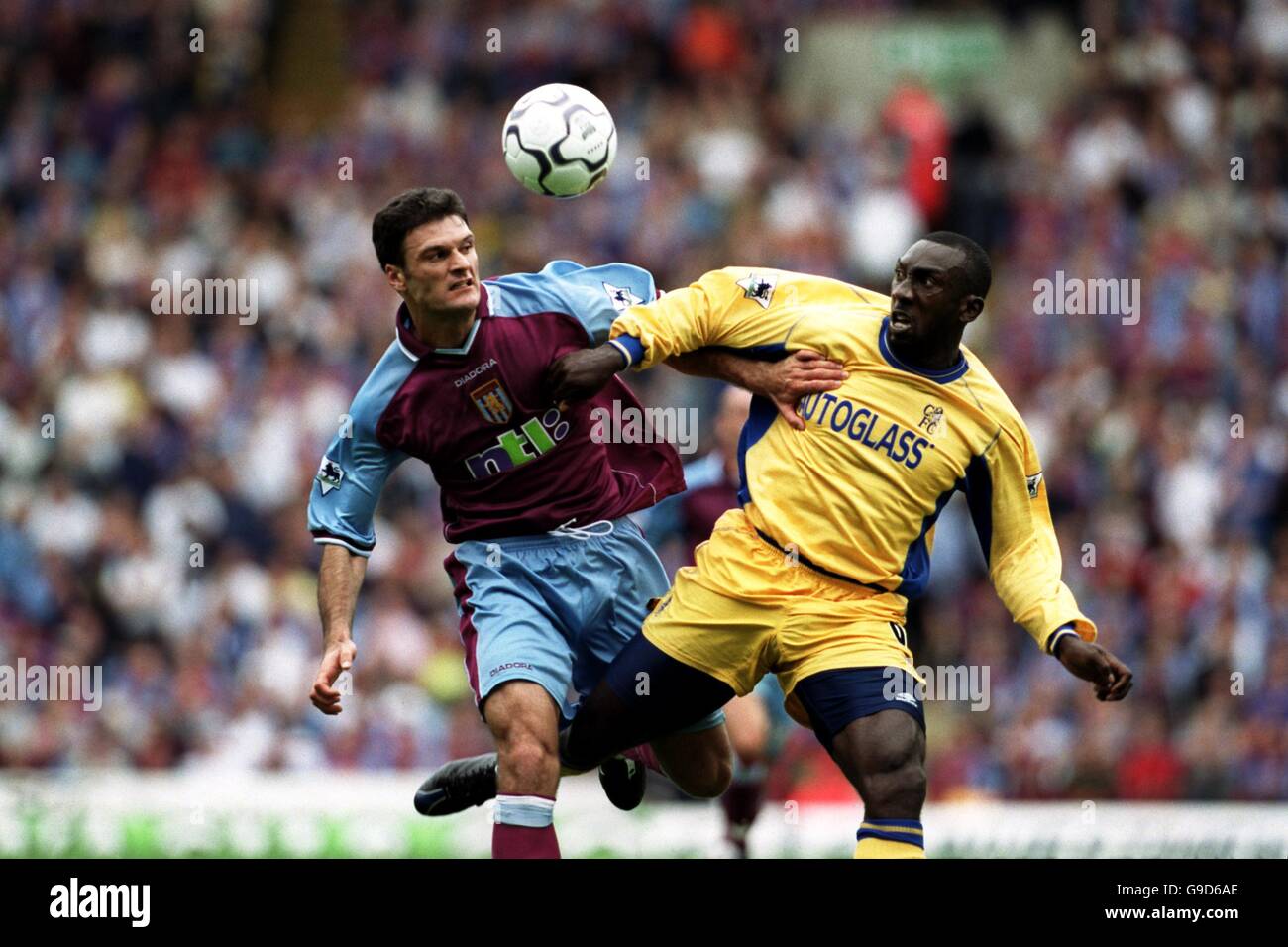 Jimmy Floyd Hasselbaink de Chelsea se trouve aux défenses d'Alpay Ozalan, une villa d'Aston Banque D'Images