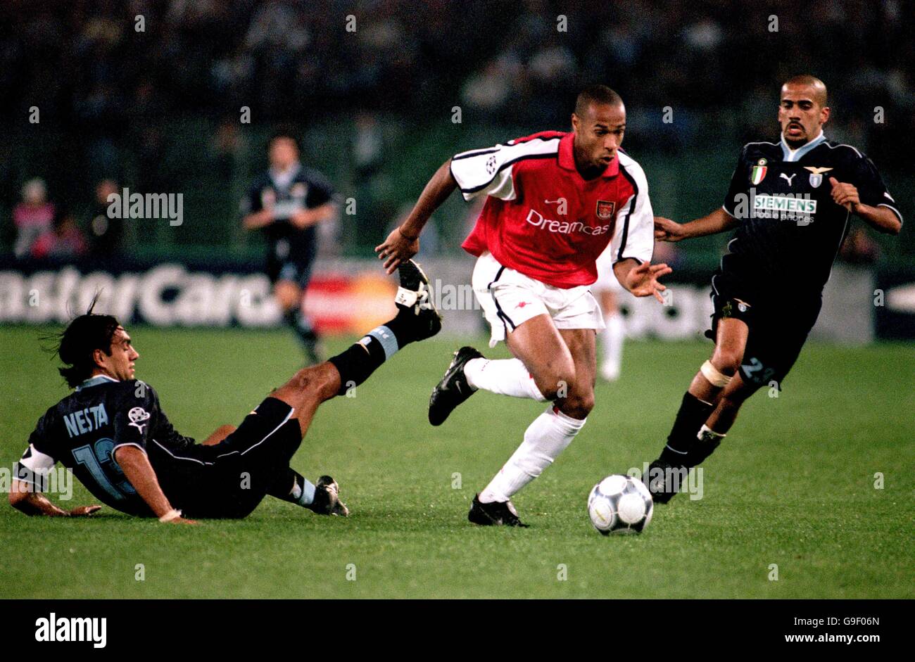 Football - Ligue des champions de l'UEFA - Groupe B - Lazio / Arsenal.Thierry Henry (c) d'Arsenal court entre Alessandro Nesta (l) du Latium et Juan Sebastian Veron (r) Banque D'Images