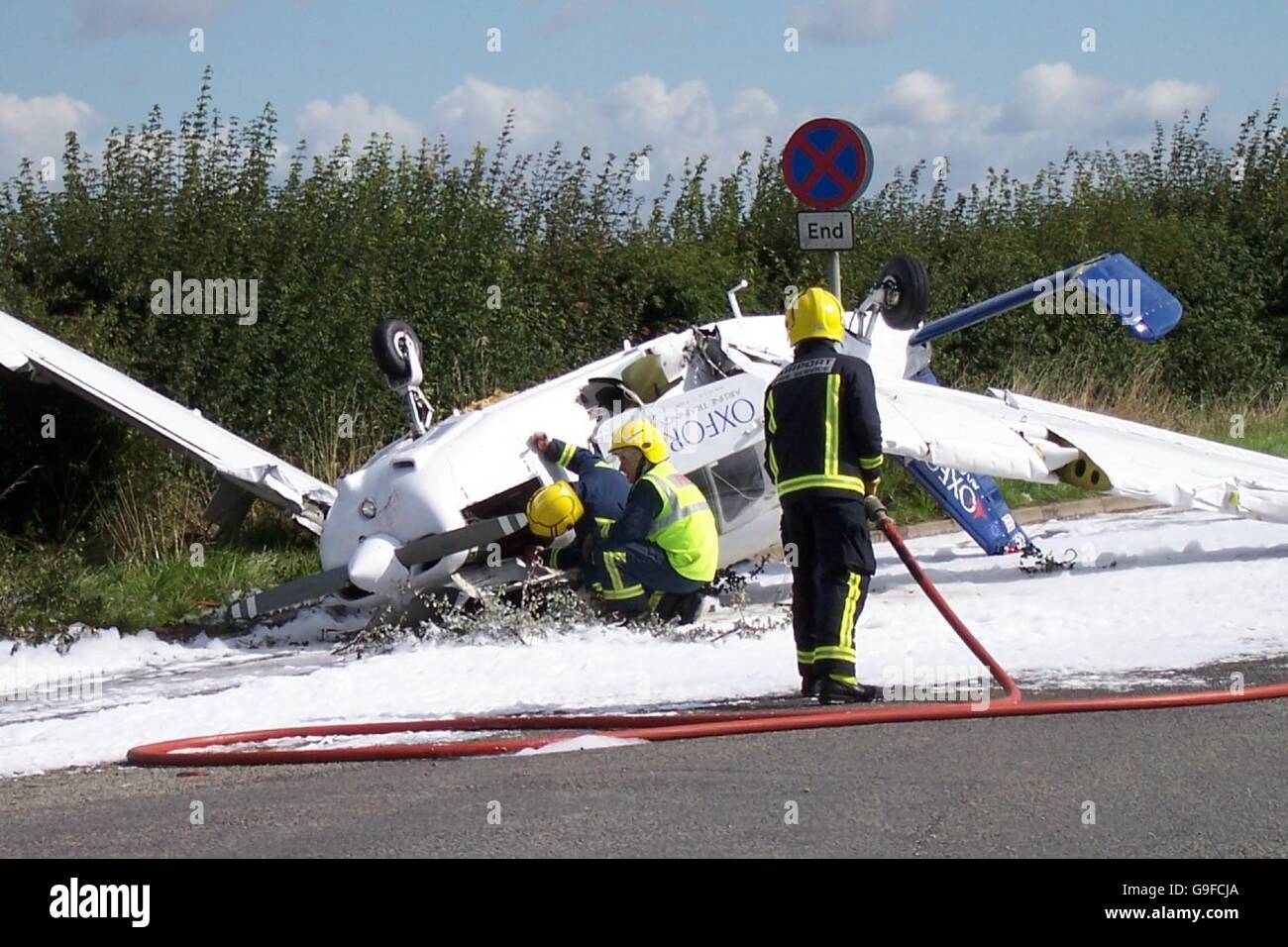 Des pompiers sur les lieux d'un accident d'avion léger sur une route latérale menant à l'A44 près d'Oxford. Banque D'Images