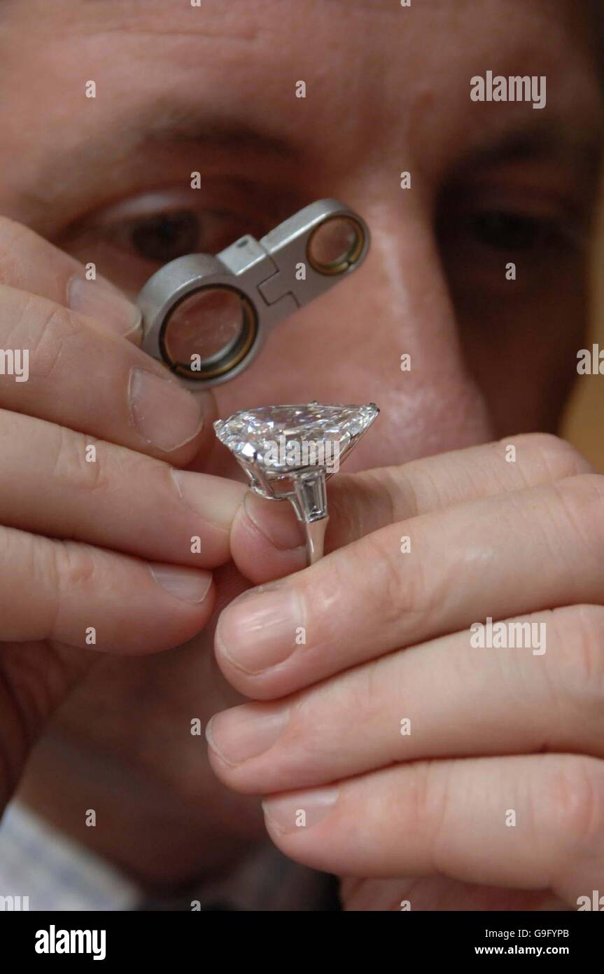 David Warren, directeur du rayon des bijoux chez Christie's, dans le centre de Londres, examine un anneau en pierre simple de diamant, qui fait partie d'une vente de la plus grande collection de bijoux de propriétaire unique jamais à vendre à la collection de vente aux enchères. Banque D'Images