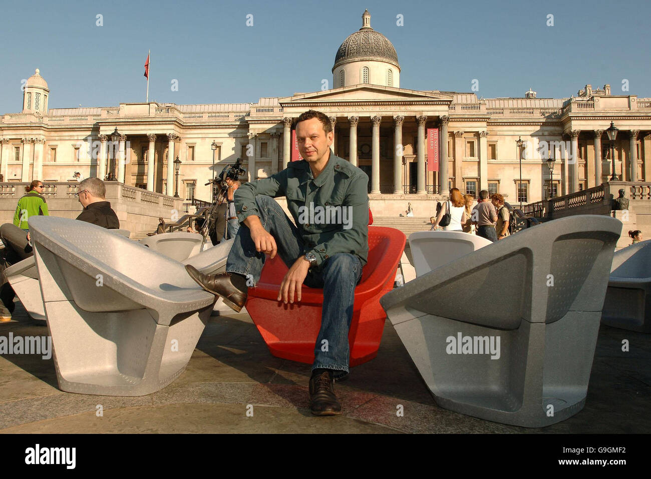 Le designer Tom Dixon est assis dans l'une de ses chaises en polystyrène expansé à Trafalgar Square, dans le centre de Londres. Banque D'Images