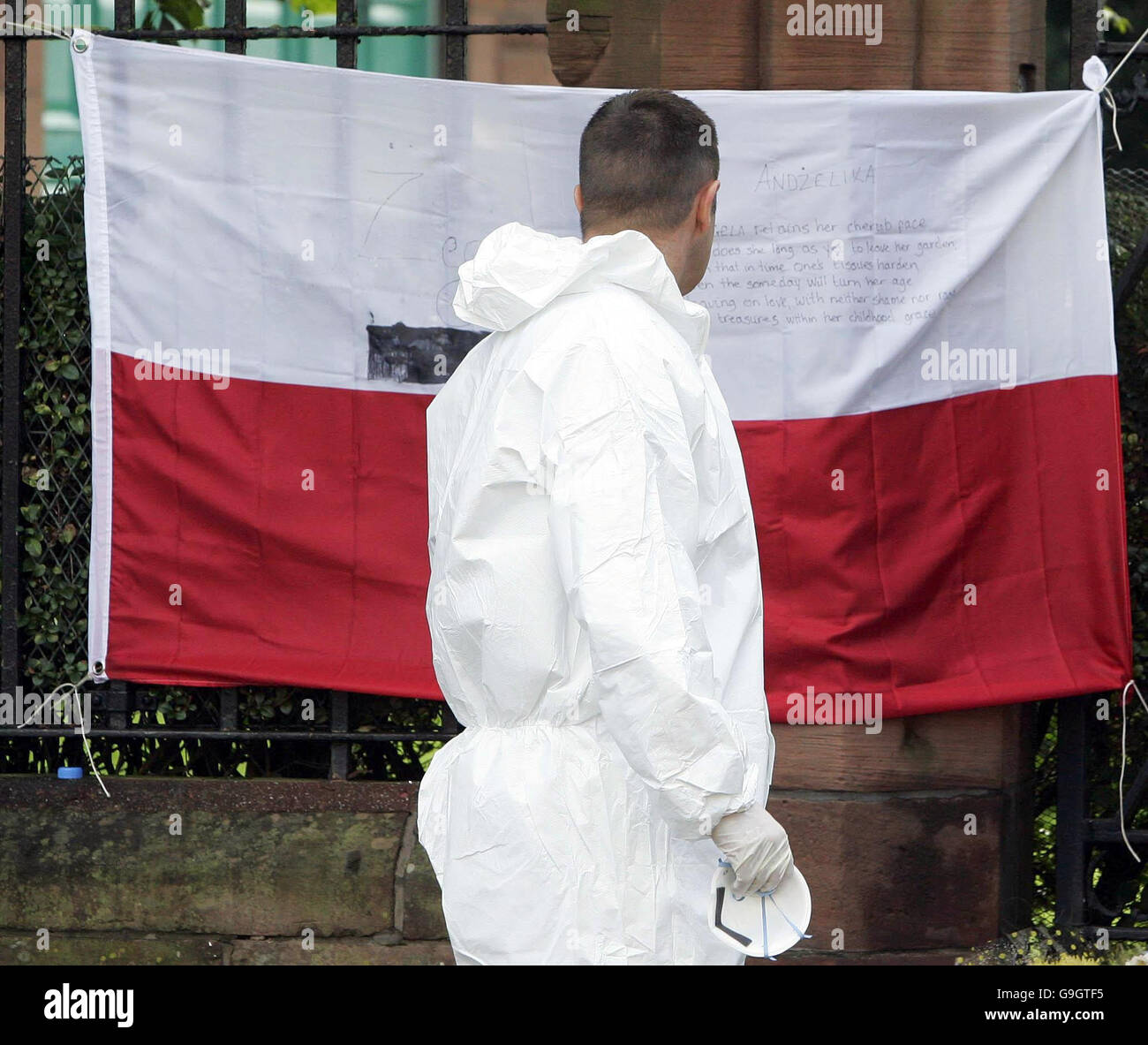 Un policier lit une note sur un drapeau polonais à l'extérieur de l'église St Patrick à Glasgow, après qu'un homme a voulu sur le meurtre de l'étudiant polonais Angelika kluk est détenu par la police car ils ont confirmé qu'un corps trouvé dans l'église était Hers. Banque D'Images