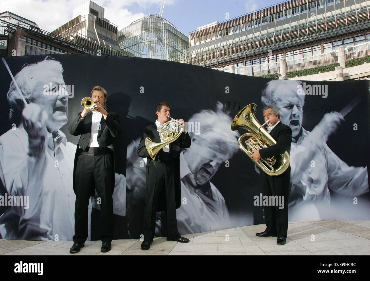 Membres de la section laiton de l'Orchestre symphonique de Londres (de gauche à droite) : Daniel Newell, Alexander Harrild et Patrick Harrild jouent devant l'une des photographies qui forment "UBS Soundscapes - le LSO dans la ville", une exposition de photos en plein air d'une semaine par le photographe suisse Alberto Venzago à la Broadgate Arena dans le centre de Londres. Banque D'Images