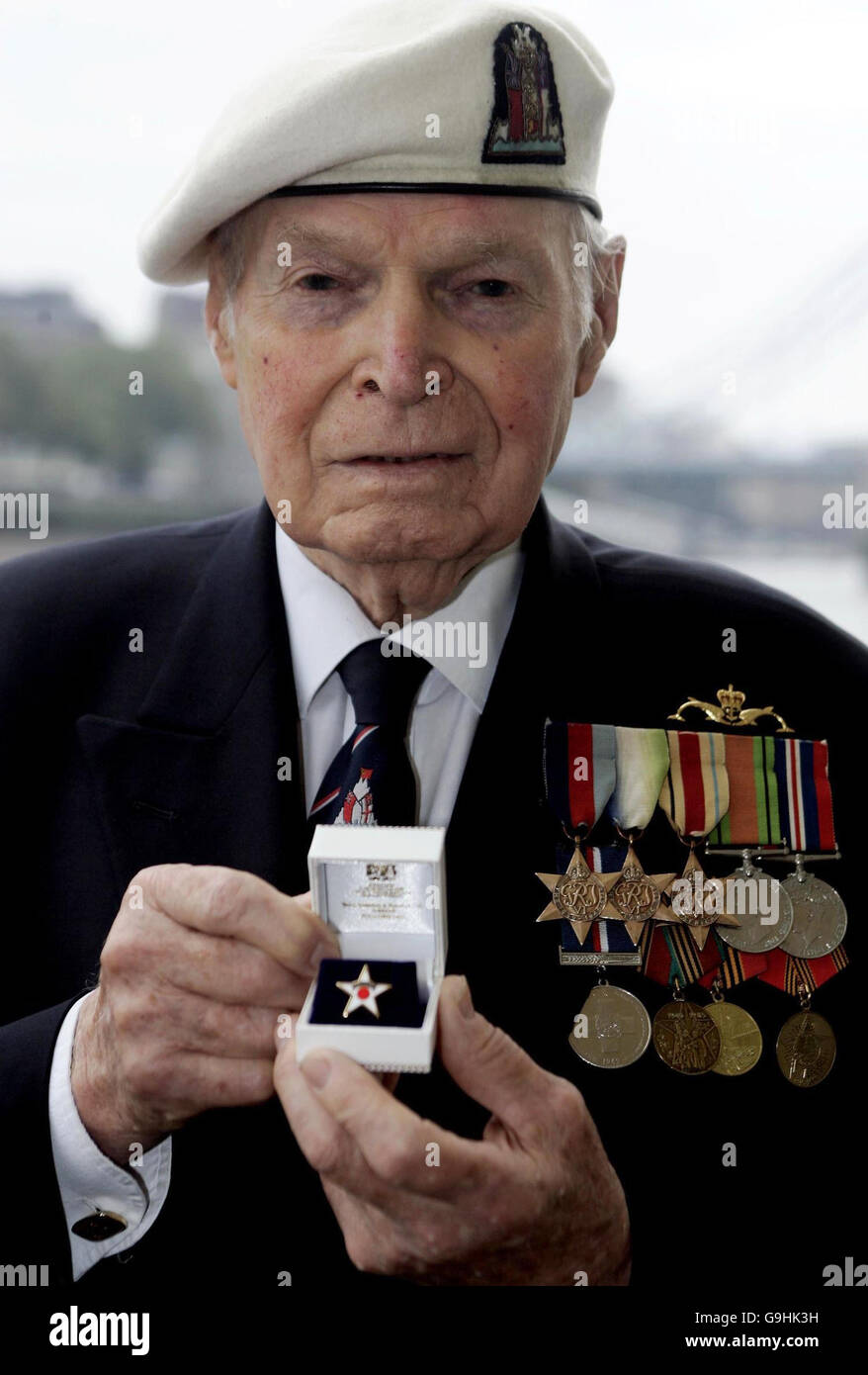 Le capitaine de corvette Eddie Grenfell, vétéran du convoi arctique, tient son emblème de bravoure à bord du HMS Belfast sur la Tamise, à Londres, après que lui et plusieurs autres vétérans aient reçu les emblèmes officiels pour marquer leur bravoure, Le 65e anniversaire de l'arrivée des premiers navires réguliers dans le port russe d'Archange. Banque D'Images