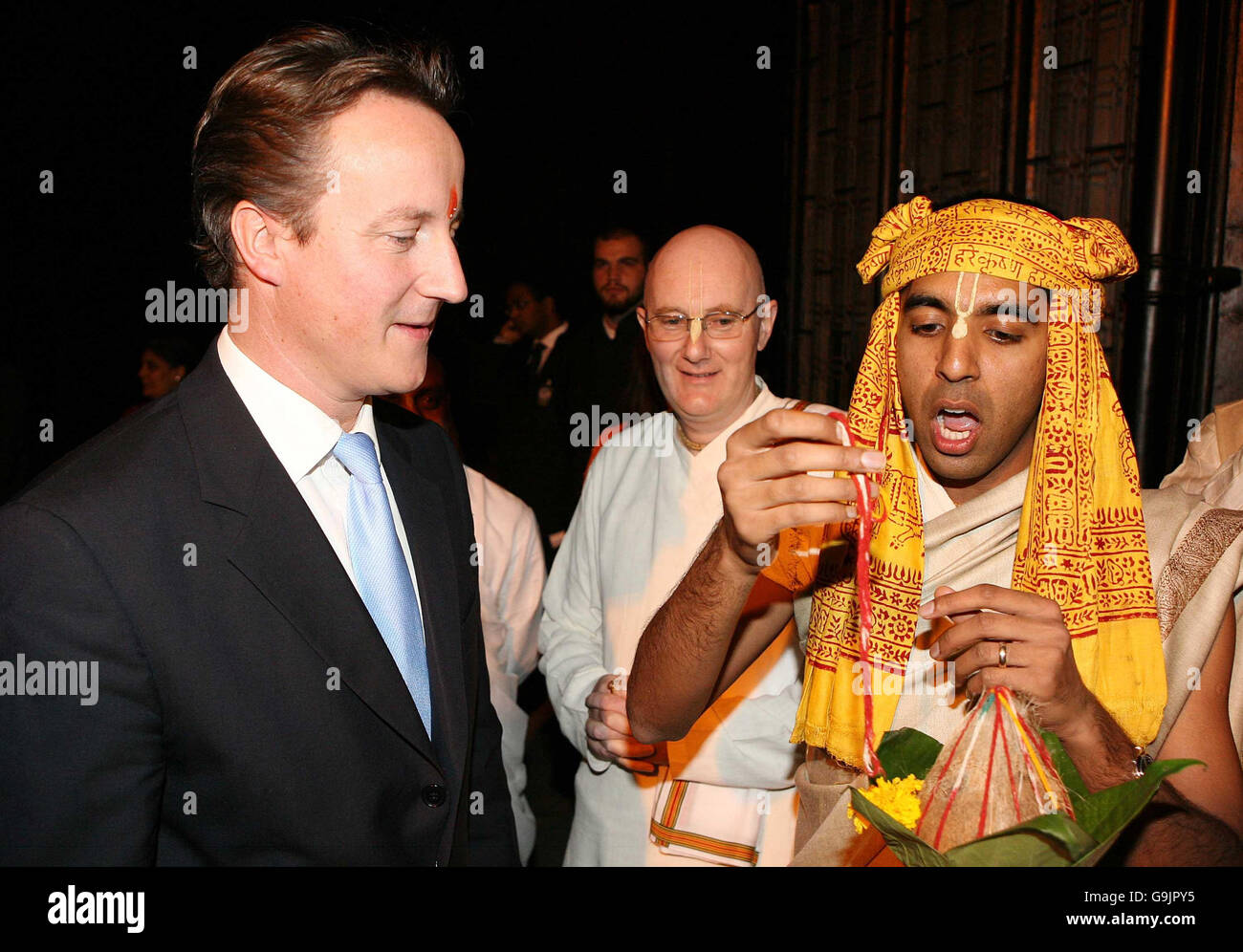 Le président du Temple Galuri Das (au centre) et le prêtre Brahmin Sri Radha Raman Das (à droite) accueillent le chef du parti conservateur David Cameron lors d'une cérémonie d'accueil spéciale au temple du manoir de Bhaktivedanta, à Watford. Banque D'Images