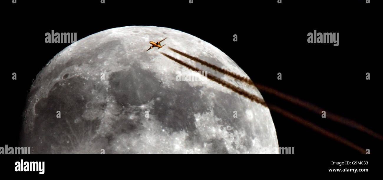 Un avion survole la lune montante le dimanche 3 décembre, vu de Chippenham dans le Wiltshire. Banque D'Images