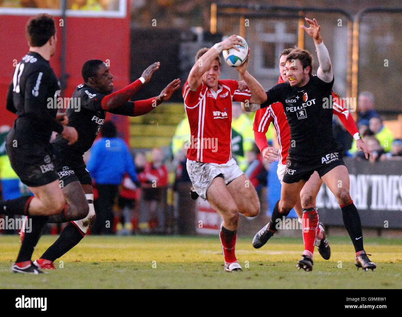 Gavin Evans de Llanelli Scarlets tente d'échapper à Yannick Nyanga et Yannick Jausion de Toulouse pendant le match de la coupe Heineken à Stradey Park, Llanelli. Banque D'Images