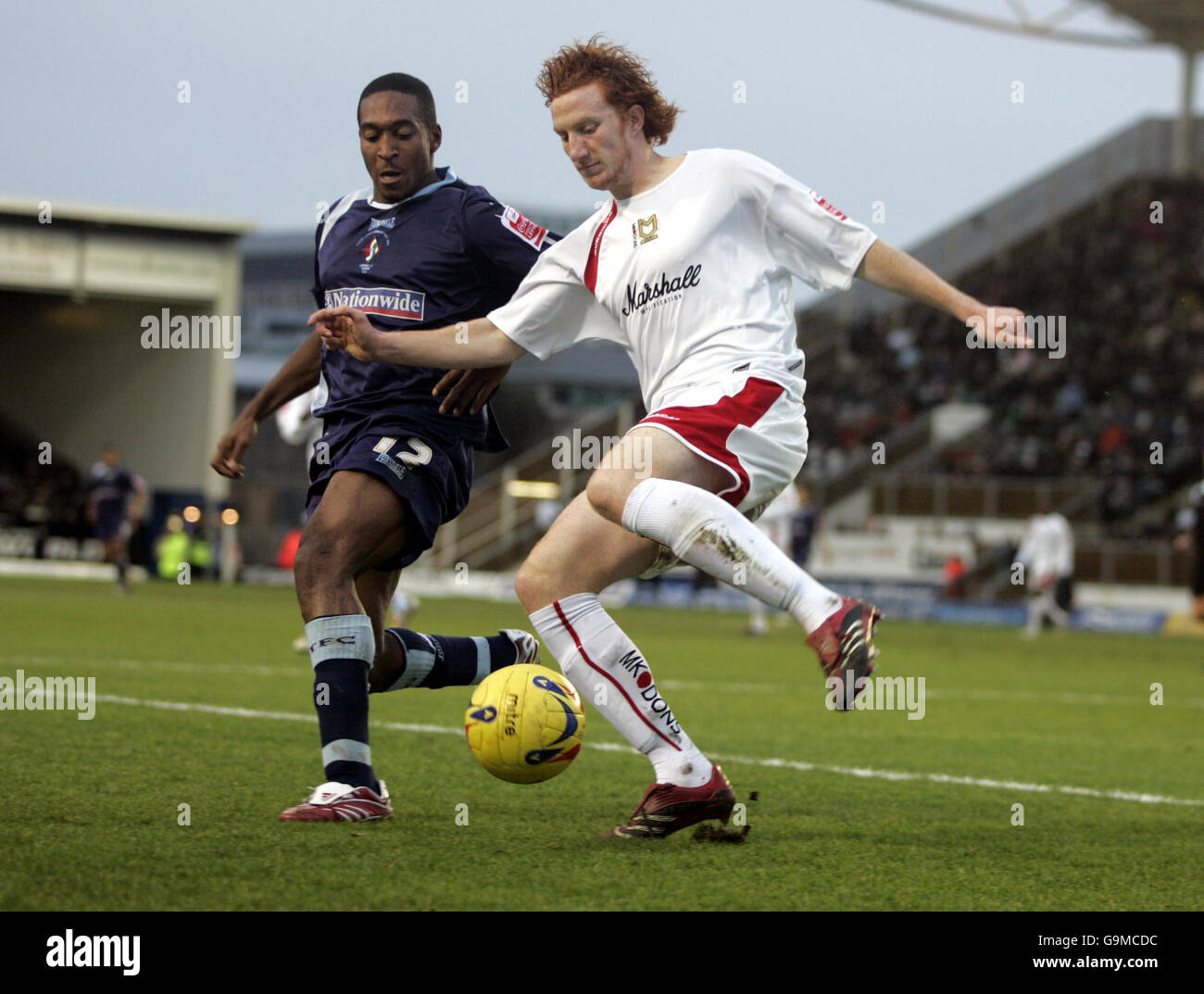 Dean Lewington de MK Dons est défié par les Milk-Shakes de Swindon lors du match de la Coca-Cola League Two au stade national de hockey de Milton Keynes. Banque D'Images