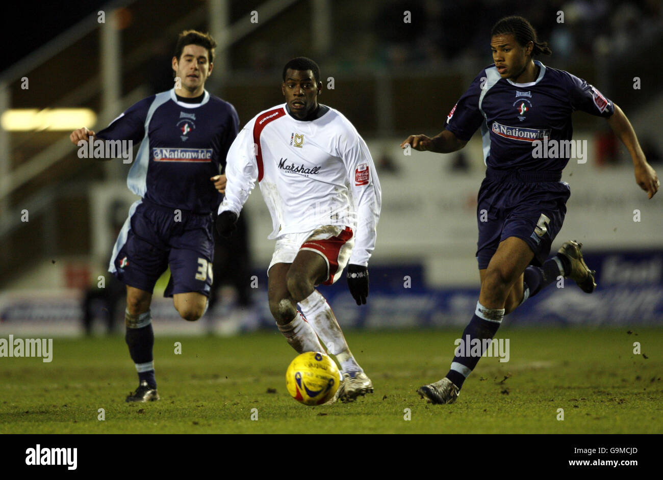 Izale McLeod (au centre) de MK Dons est défié par Michael Timlin (à gauche) de Swindon et Jerel Ifil lors du match de la Coca-Cola League Two au stade national de hockey de Milton Keynes. Banque D'Images