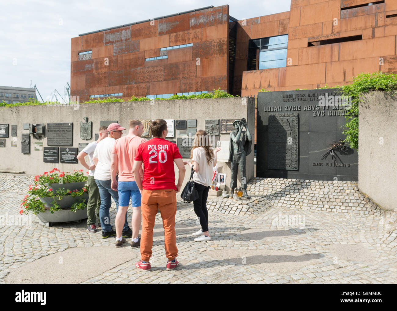 Tour guide montrant groupe de touristes la sculpture d'un travailleur de chantier naval de Gdansk et liste des travailleurs tués en 1970 - Gdansk, Pola Banque D'Images