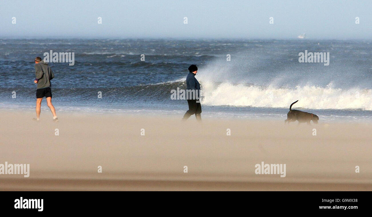 Les vents de la force de Gale ont balayé le pays tandis que les marcheurs se promenent sur la plage de tynemouth. Banque D'Images