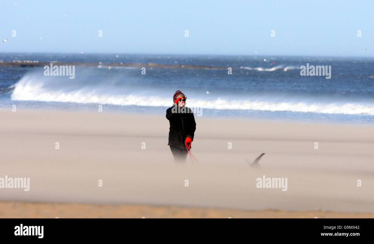 Les vents de la force de Gale ont balayé le pays tandis que les marcheurs se promenent sur la plage de tynemouth. Banque D'Images
