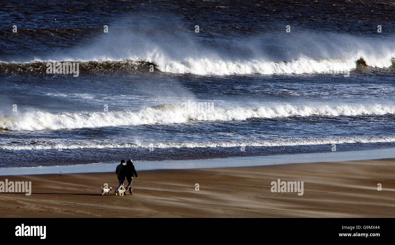 Les vents de la force de Gale ont balayé le pays tandis que les marcheurs se promenent sur la plage de tynemouth. Banque D'Images