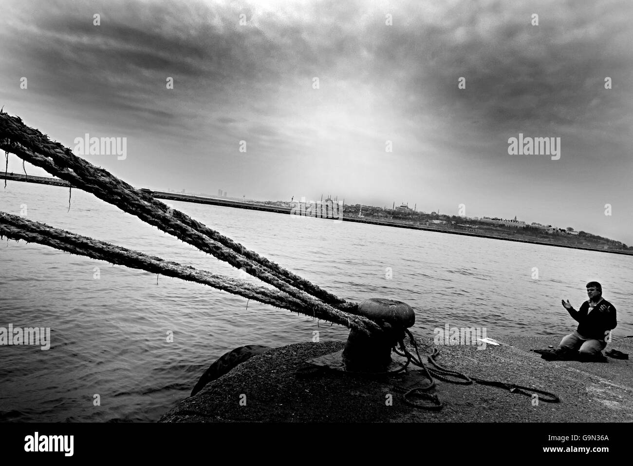 . Un homme qui prie dans Haydarpaşa Port. Haydarpasa est terminal qui est d'abord les immigrants viennent à Istanbul. Banque D'Images